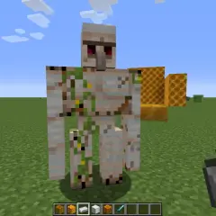 Żelazny golem stoi na trawie, obok plastrów miodu. Jak zdobyć krzemień w Minecraft?