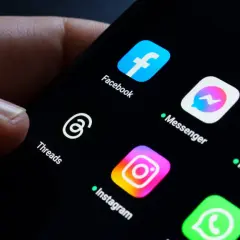 Palec dotyka ekranu telefonu z ikonami aplikacji Meta: Facebook, Messenger, Instagram, Threads. Awaria Facebooka sprawia, że użytkownicy szukają alternatyw.