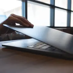 Dłoń zamyka smukły ultrabook. Co to jest? Lekki, wydajny laptop do pracy i rozrywki.