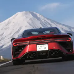 Czerwony sportowy samochód pędzi drogą z widokiem na ośnieżoną górę. Czy to zapowiedź forza horizon 6 premiera?