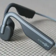 Słuchawki AfterShokz, idealne, gdy zastanawiasz się, jakie słuchawki na rower wybrać. Pozwalają słyszeć otoczenie.