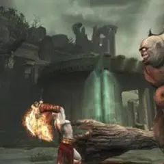 Kratos z płonącym ostrzem walczy z olbrzymim potworem w mrocznym świecie God of War 2.