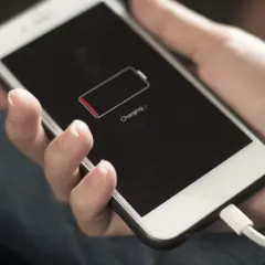 Dłoń trzyma telefon z ikoną niskiego poziomu baterii. Zastanawiasz się, power bank 50000 mah na ile starcza?