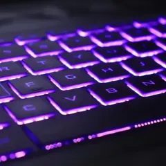 Klawiatura laptopa Lenovo z fioletowym podświetleniem. Dowiedz się, jak włączyć podświetlenie klawiatury w laptopie Lenovo, aby ułatwić sobie pracę w ciemności.