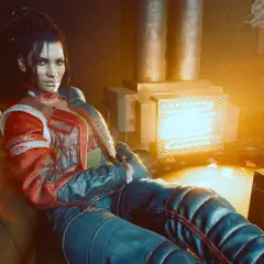 Panam Palmer, w skórzanej kurtce, siedzi przytulona do kanapy, w blasku ciepłego światła. To początek cyberpunk romansu z Panam.