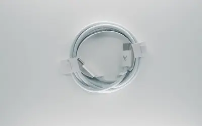 Biały, pleciony kabel **usb typu c** z logo marki, zwinięty w okrąg i zabezpieczony papierowymi opaskami.