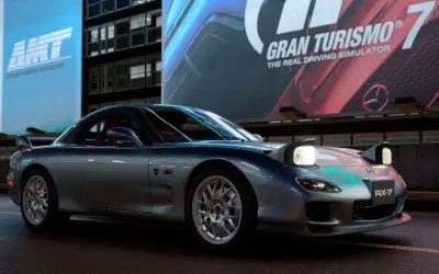 Srebrne RX-7 z podniesionymi światłami, gotowe do jazdy w Gran Turismo 7.