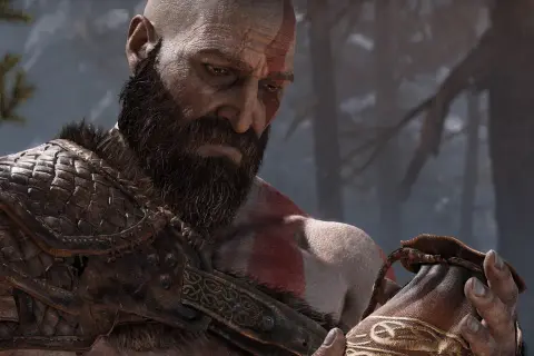 Kratos z brodą i czerwonymi znakami na twarzy, w zbroi, trzyma sakiewkę. Dzieło Santa Monica Studio.