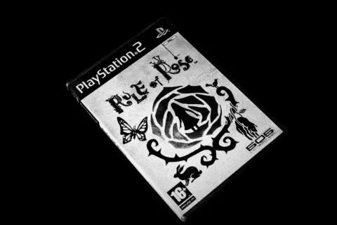 Okładka gry "Rule of Rose" na PlayStation 2. Motyw czarnej róży, motyla i królika.