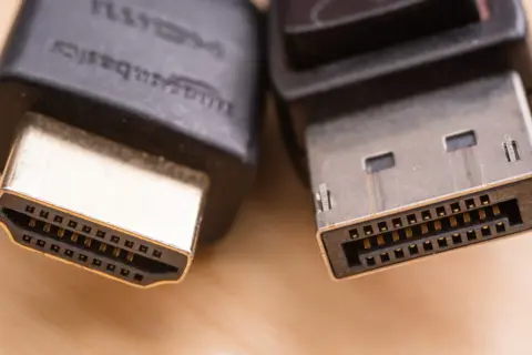 Zbliżenie na wtyczki HDMI i DisplayPort, pokazujące różnice w ich budowie. Który kabel wybrać?