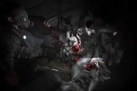 Postapokaliptyczna walka z potworami. Postać w masce gazowej mierzy się z przerażającym królem szczurów z The Last of Us.