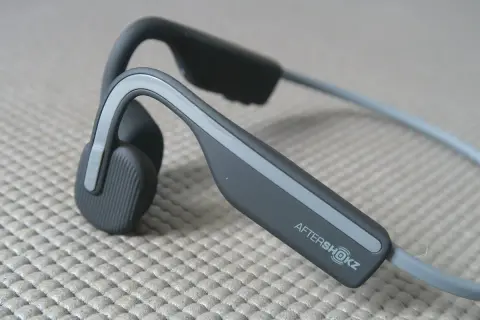 Słuchawki AfterShokz, idealne, gdy zastanawiasz się, jakie słuchawki na rower wybrać. Pozwalają słyszeć otoczenie.