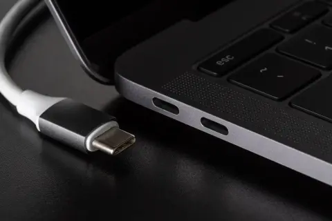 Kabel USB-C podłączony do laptopa. Różne rodzaje USB ewoluują, a ten nowoczesny standard zapewnia wszechstronność.