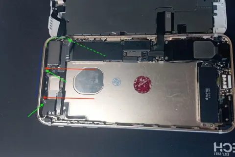 Wnętrze telefonu z widocznym modułem **NFC w telefonie**. Widać elementy płyty głównej, baterię i Taptic Engine.