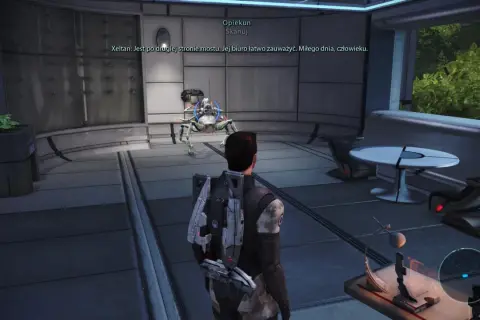 W grze Mass Effect, opiekunowie pomagają w nawigacji. Postać gracza stoi przed mechanicznym stworzeniem w futurystycznym wnętrzu.