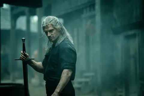 Geralt z Rivii, **the witcher**, z długimi, siwymi włosami i mieczem w dłoni, spogląda groźnie.