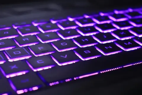 Klawiatura laptopa Lenovo z fioletowym podświetleniem. Dowiedz się, jak włączyć podświetlenie klawiatury w laptopie Lenovo, aby ułatwić sobie pracę w ciemności.