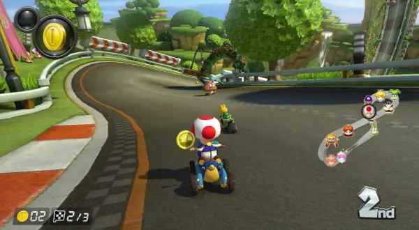 Wyścig w Mario Kart na PS5: Toad na drugim miejscu zbiera monety, a za nim jedzie Yoshi.