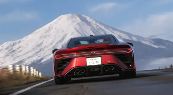 Czerwony sportowy samochód pędzi drogą z widokiem na ośnieżoną górę. Czy to zapowiedź forza horizon 6 premiera?