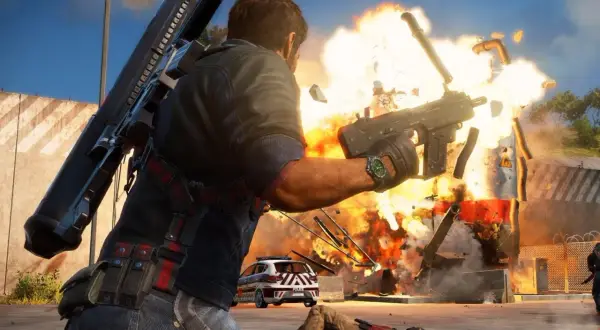 Rico Rodriguez strzela z pistoletu maszynowego, wywołując eksplozję. W tle policyjny radiowóz i powalony przeciwnik. Idealne dla graczy szukających wyzwań, jak w Just Cause 3 wymagania.