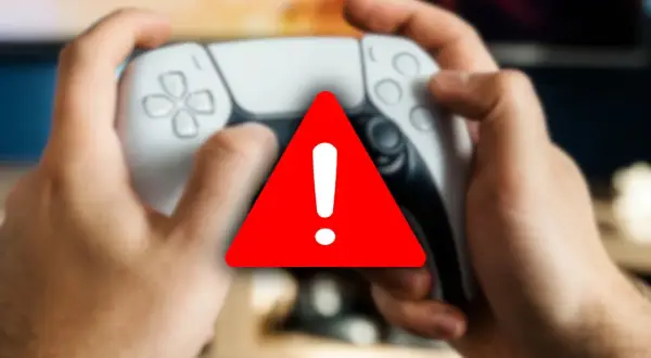 Ręce trzymające kontroler PlayStation, na którym widnieje czerwony trójkąt z wykrzyknikiem, symbolizujący awarię.