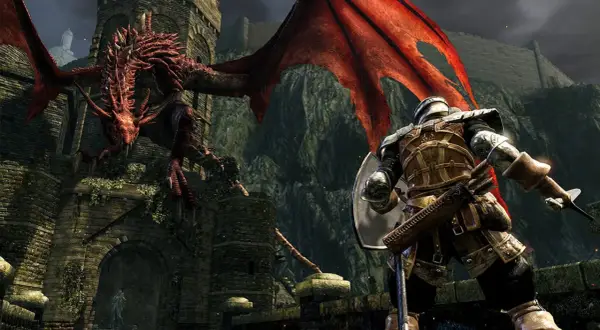 Rycerz w zbroi staje naprzeciw czerwonego smoka. To scena z gry Dark Souls, idealna do poradnika.