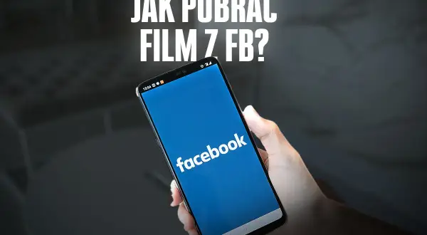 Dłoń trzyma smartfon z otwartą aplikacją Facebook. Napis "JAK POBLRAĆ FILM Z FB?" sugeruje poradnik.
