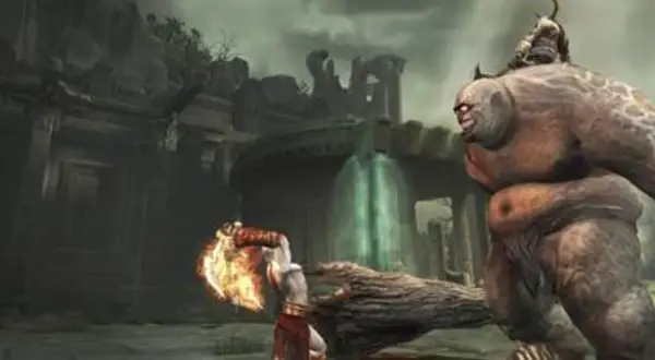 Kratos z płonącym ostrzem walczy z olbrzymim potworem w mrocznym świecie God of War 2.