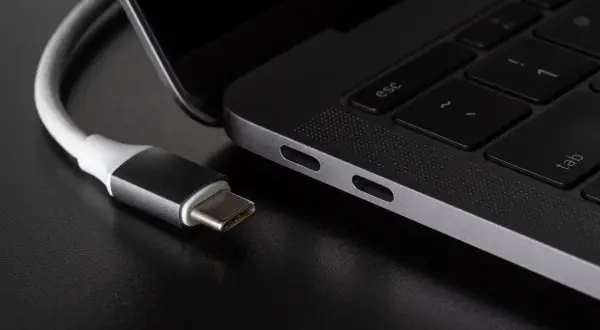 Kabel USB-C podłączony do laptopa. Różne rodzaje USB ewoluują, a ten nowoczesny standard zapewnia wszechstronność.