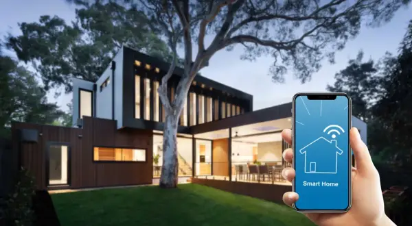 Nowoczesny dom z ogrodem, sterowany przez aplikację Smart Home na telefonie.
