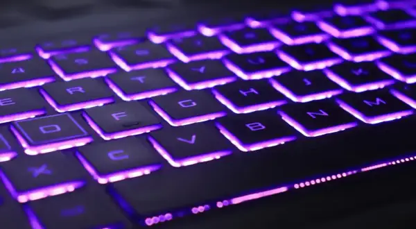 Klawiatura laptopa Lenovo z fioletowym podświetleniem. Dowiedz się, jak włączyć podświetlenie klawiatury w laptopie Lenovo, aby ułatwić sobie pracę w ciemności.