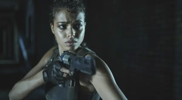 Kobieta z pistoletem, zdeterminowana, w mrocznym otoczeniu. Czy to Jill Valentine z Resident Evil Remedium?