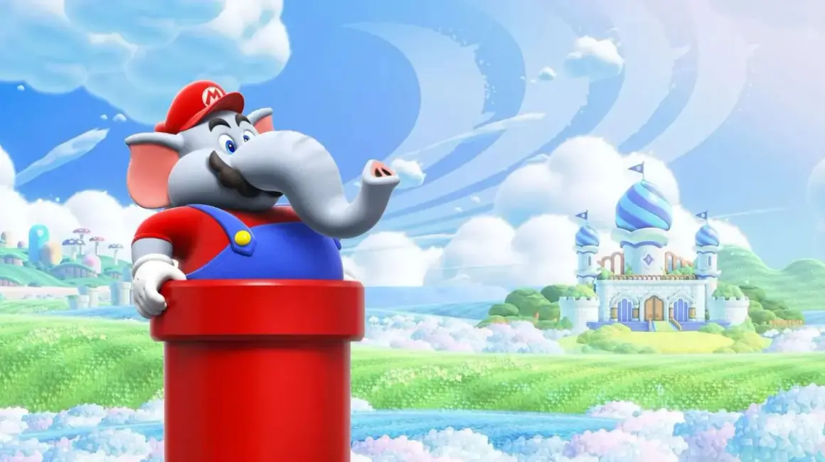 Słoń Mario z serii Super Mario wychyla się z czerwonej rury na tle bajkowej krainy z zamkiem.