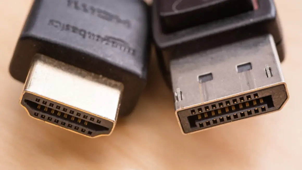 Zbliżenie na wtyczki HDMI i DisplayPort, pokazujące różnice w ich budowie. Który kabel wybrać?