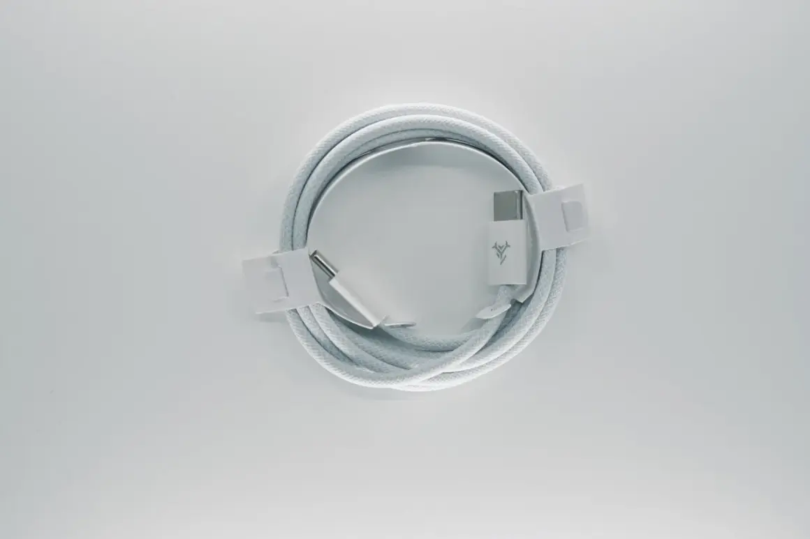Biały, pleciony kabel **usb typu c** z logo marki, zwinięty w okrąg i zabezpieczony papierowymi opaskami.