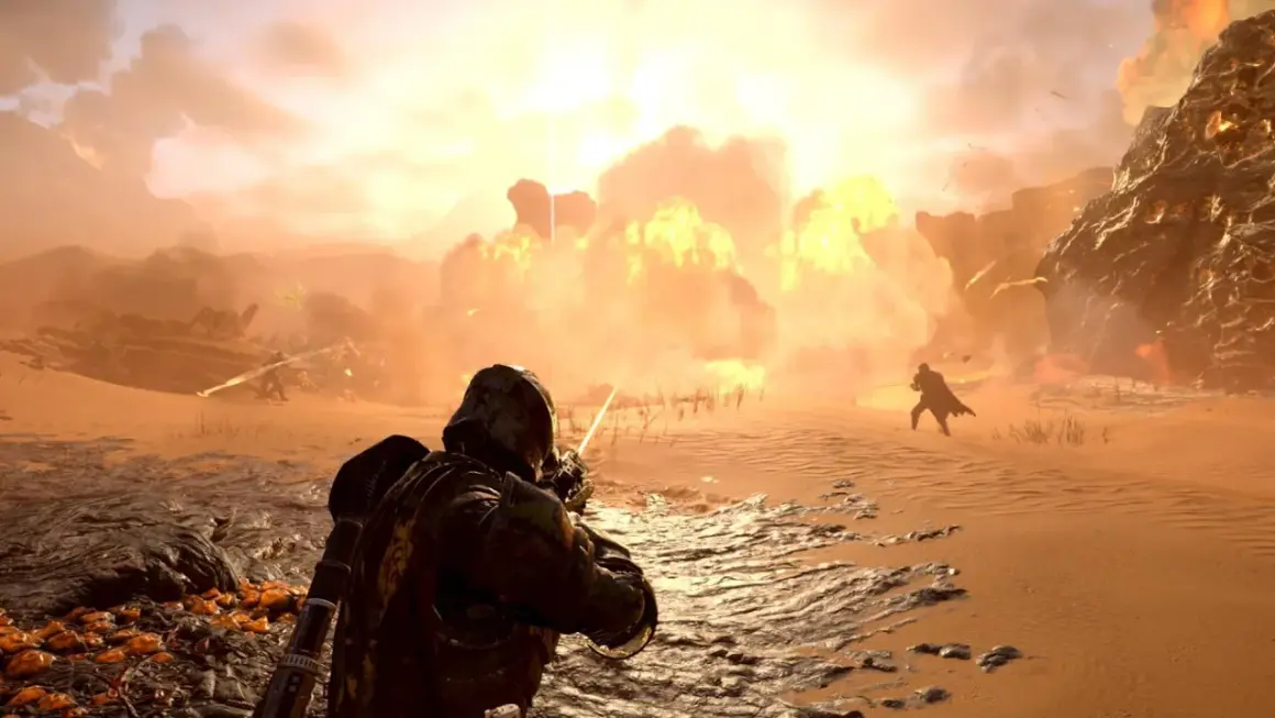 Helldivers 2: żołnierz strzela na pustynnym polu bitwy, podczas gdy w tle wybucha potężna eksplozja.