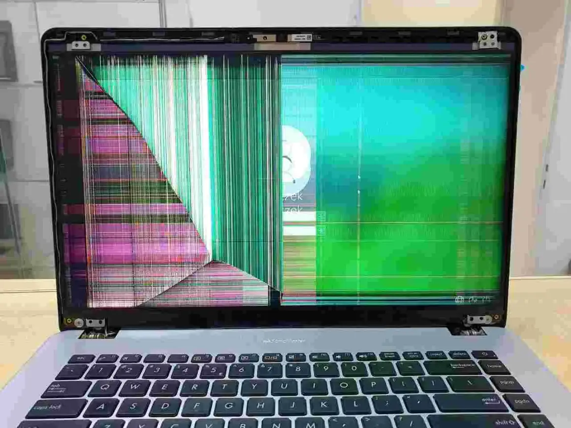 Uszkodzona matryca w laptopie wyświetla kolorowe paski i zakłócenia, uniemożliwiając normalne użytkowanie.