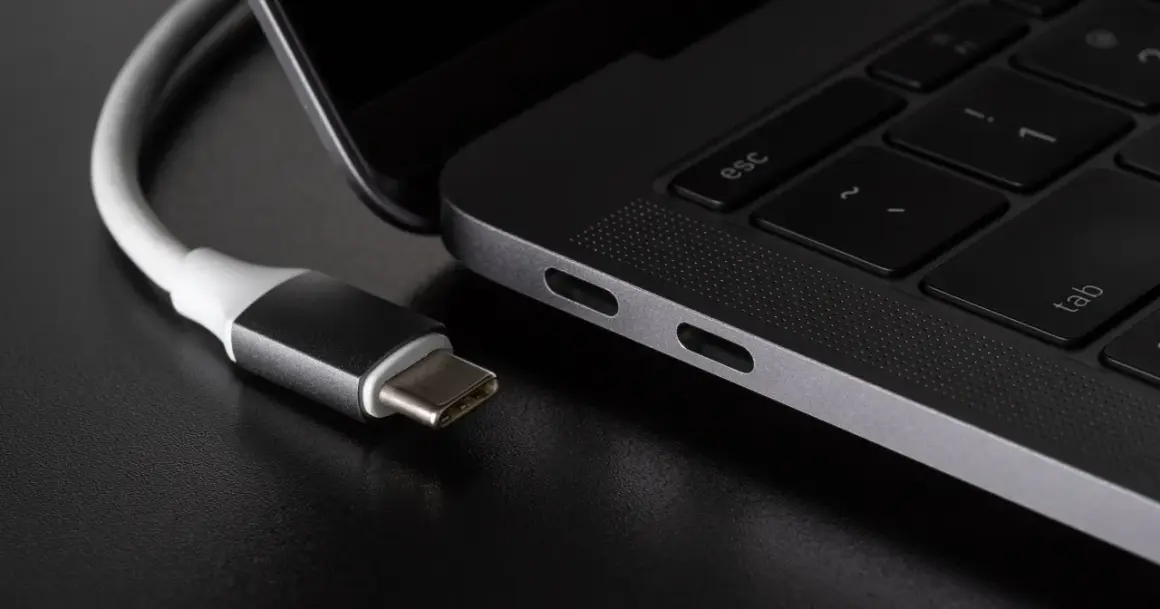 Kabel USB-C podłączony do laptopa. Różne rodzaje USB ewoluują, a ten nowoczesny standard zapewnia wszechstronność.