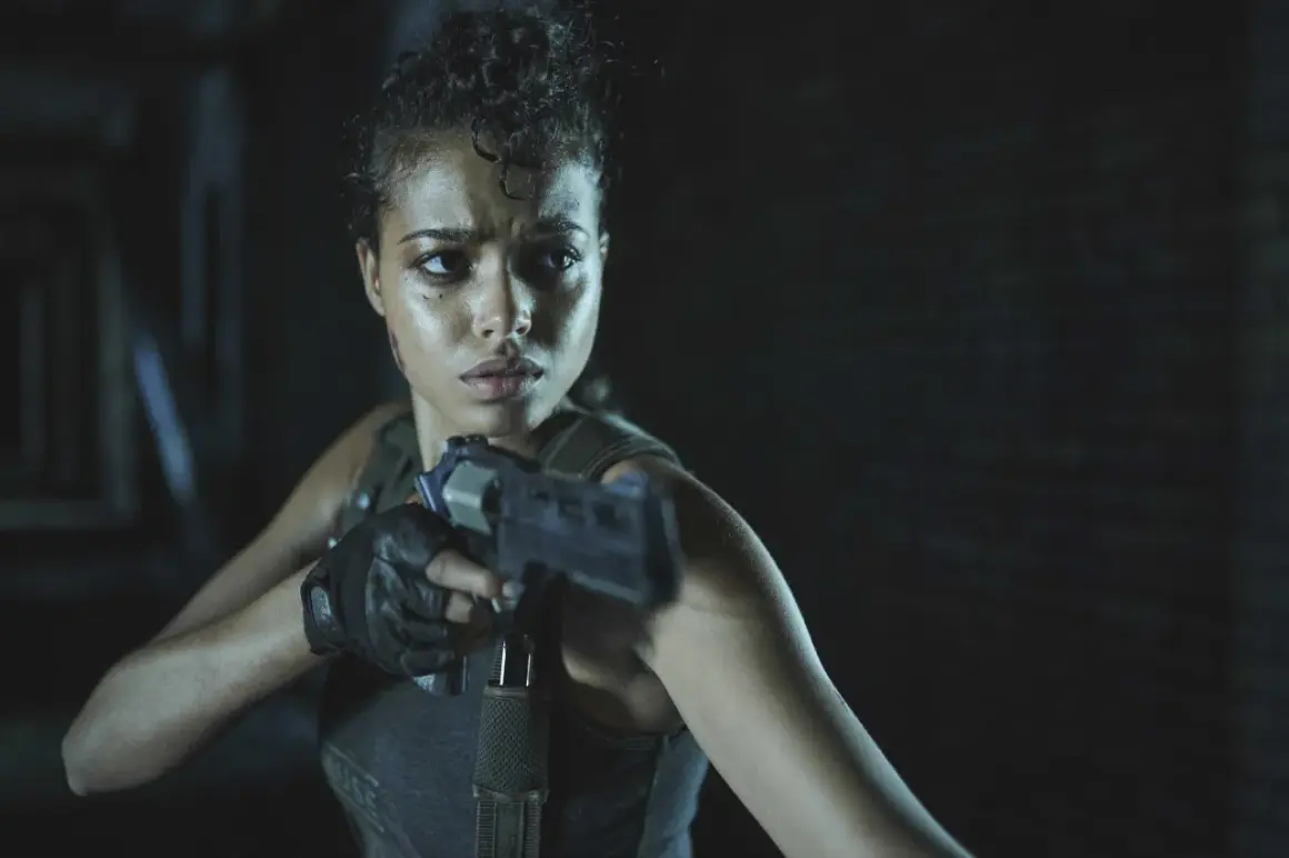 Kobieta z pistoletem, zdeterminowana, w mrocznym otoczeniu. Czy to Jill Valentine z Resident Evil Remedium?