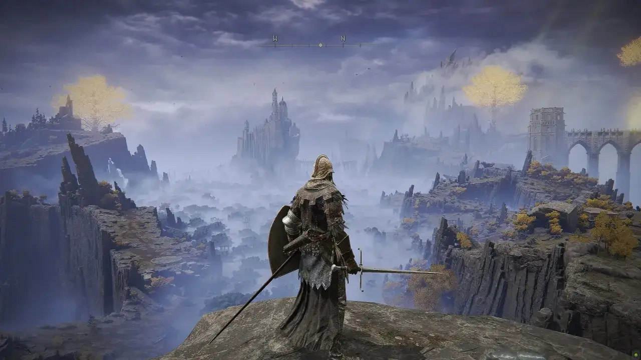 Rycerz z mieczem i tarczą patrzy na mglistą dolinę z zamkiem w oddali. To piękny widok z gry od FromSoftware.