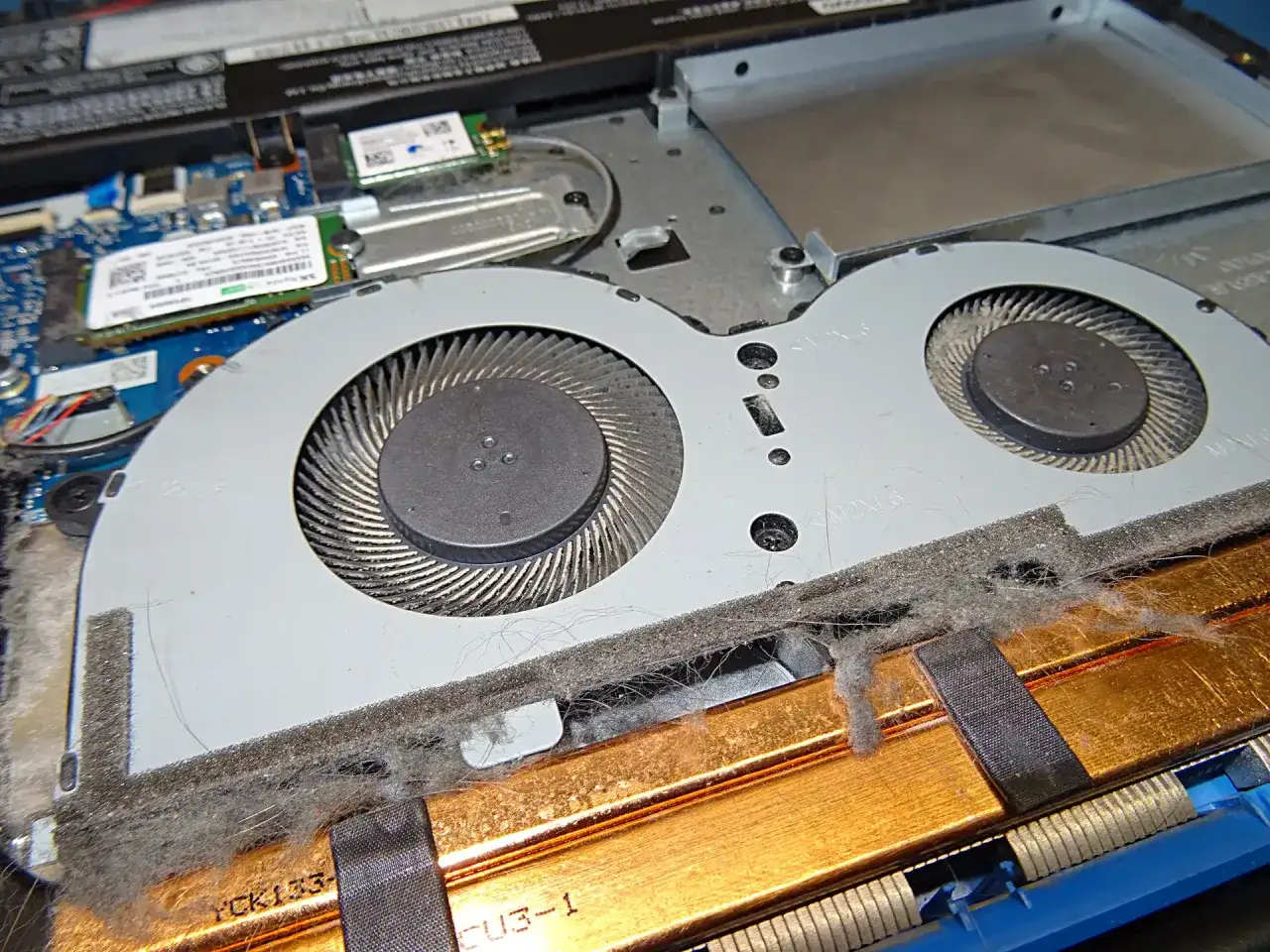 Wnętrze laptopa po wymianie procesora: zakurzone wentylatory i radiator.