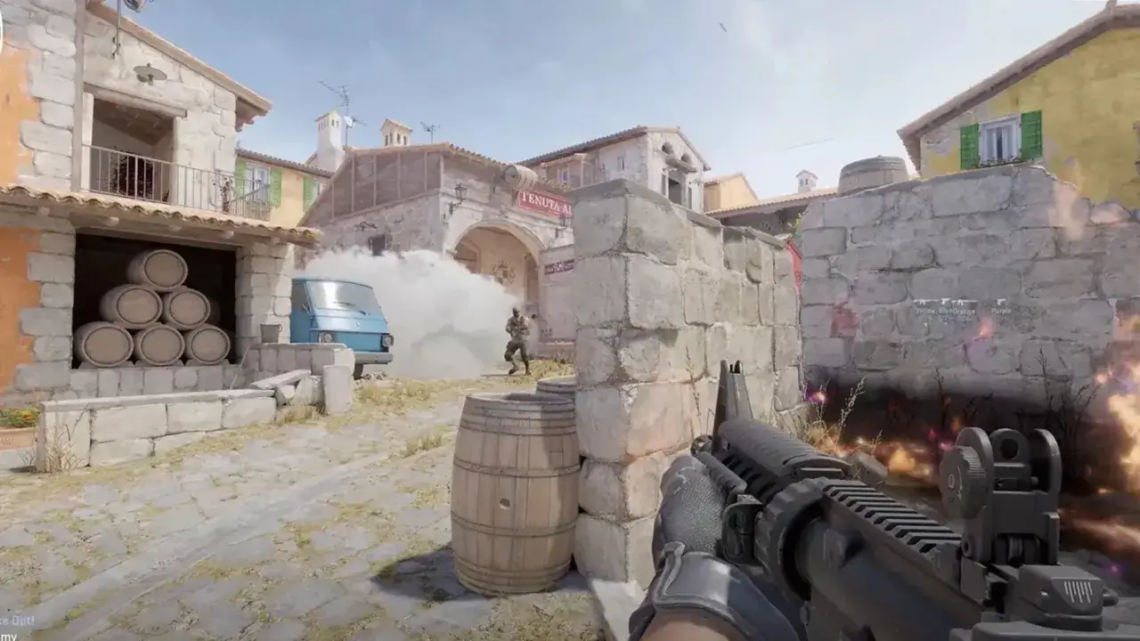 Gracz Counter-Strike 2 celuje z karabinu, ukryty za murem. W tle dym i wybuchy.