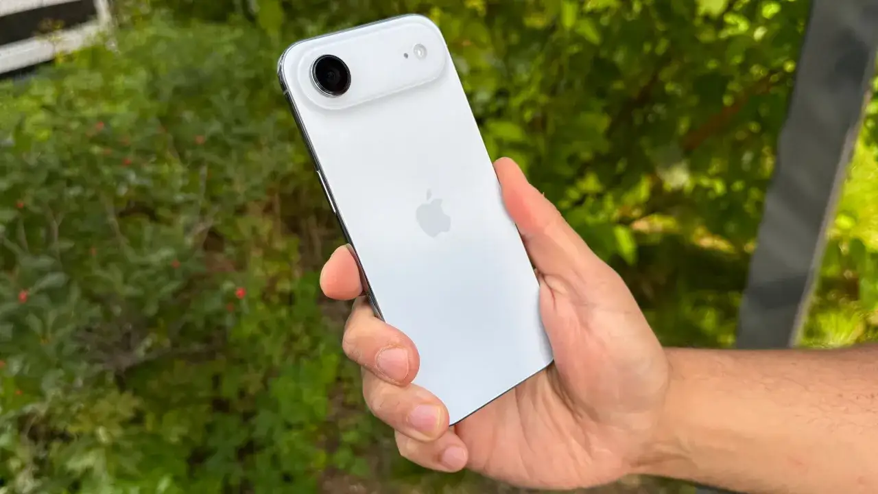 Biały iPhone 17 Air w dłoni, z widocznym modułem aparatu i jabłkiem Apple.