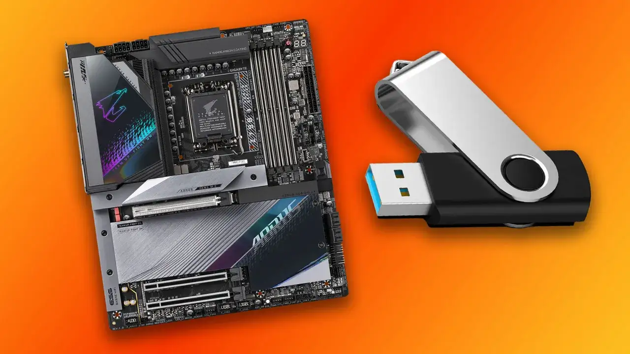 Płyta główna Aorus i pendrive na pomarańczowym tle.