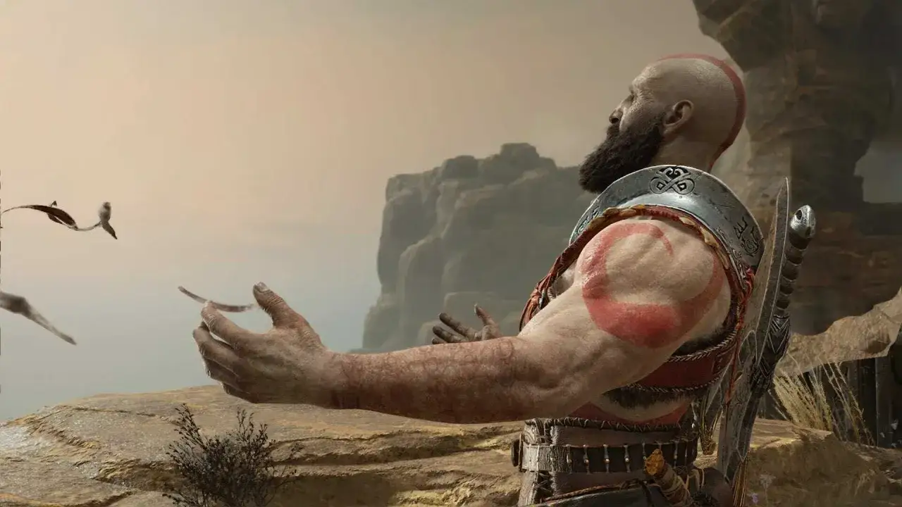 Kratos z God of War poradnik, z uniesionymi rękami, w surowym krajobrazie.