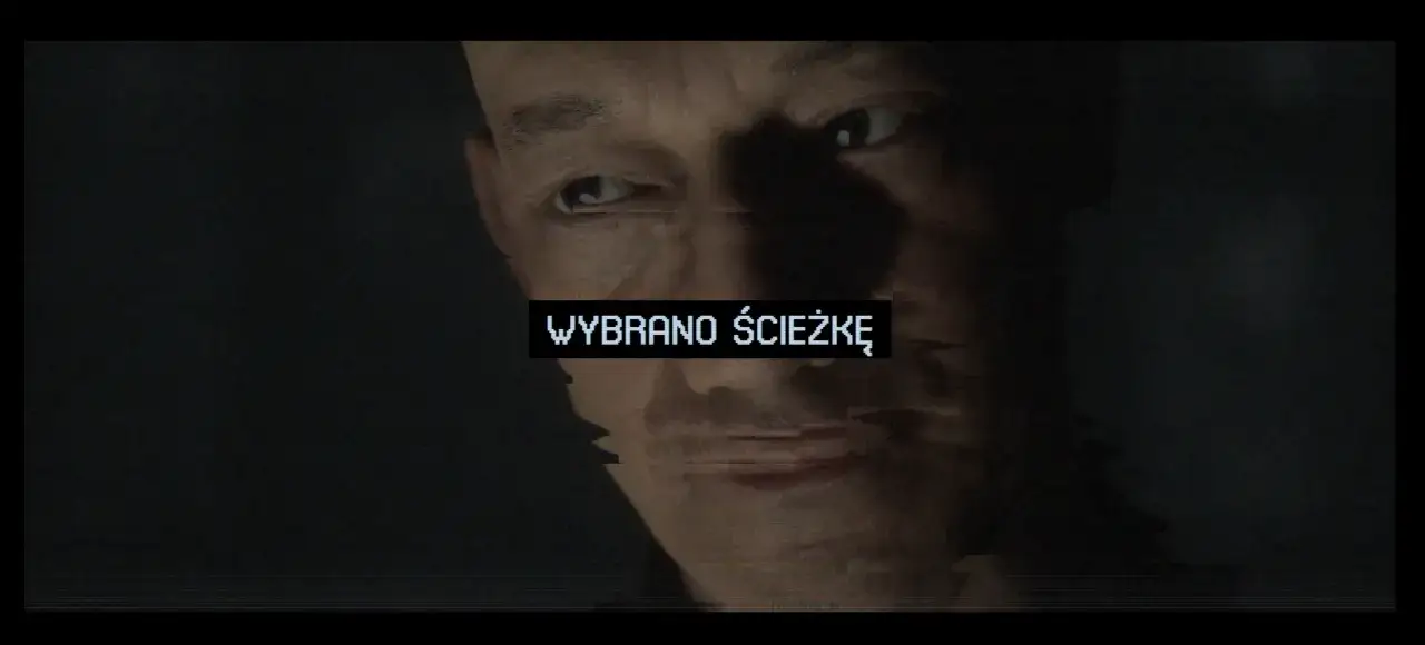 Mężczyzna z niepokojem patrzy w kamerę. Na ekranie pojawia się napis 