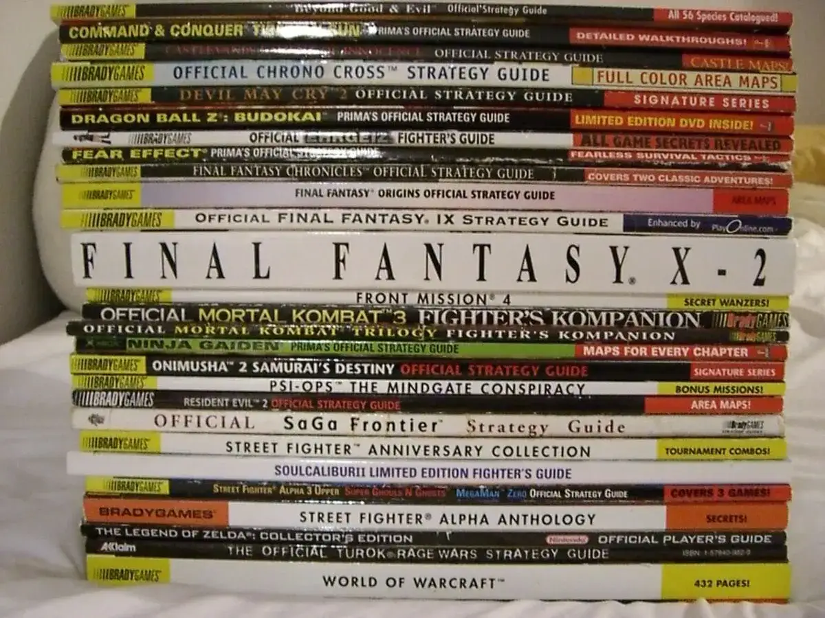 Stos książek z poradniki do gier, w tym Final Fantasy, Mortal Kombat, Street Fighter i inne.