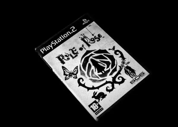Okładka gry "Rule of Rose" na PlayStation 2. Motyw czarnej róży, motyla i królika.