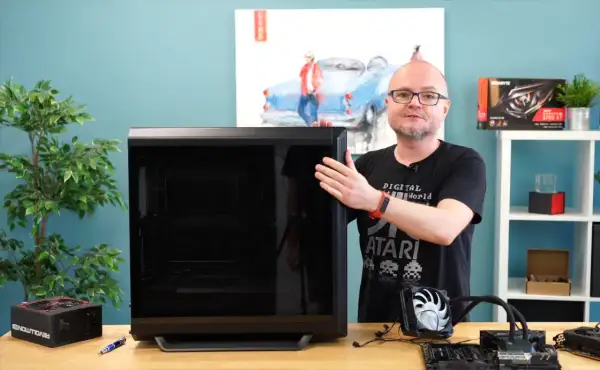Mężczyzna pokazuje obudowę komputera, obok leży zasilacz i elementy do złożenia PC. Poradnik: jak złożyć komputer.