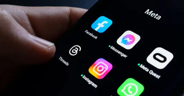 Palec dotyka ekranu telefonu z ikonami aplikacji Meta: Facebook, Messenger, Instagram, Threads. Awaria Facebooka sprawia, że użytkownicy szukają alternatyw.